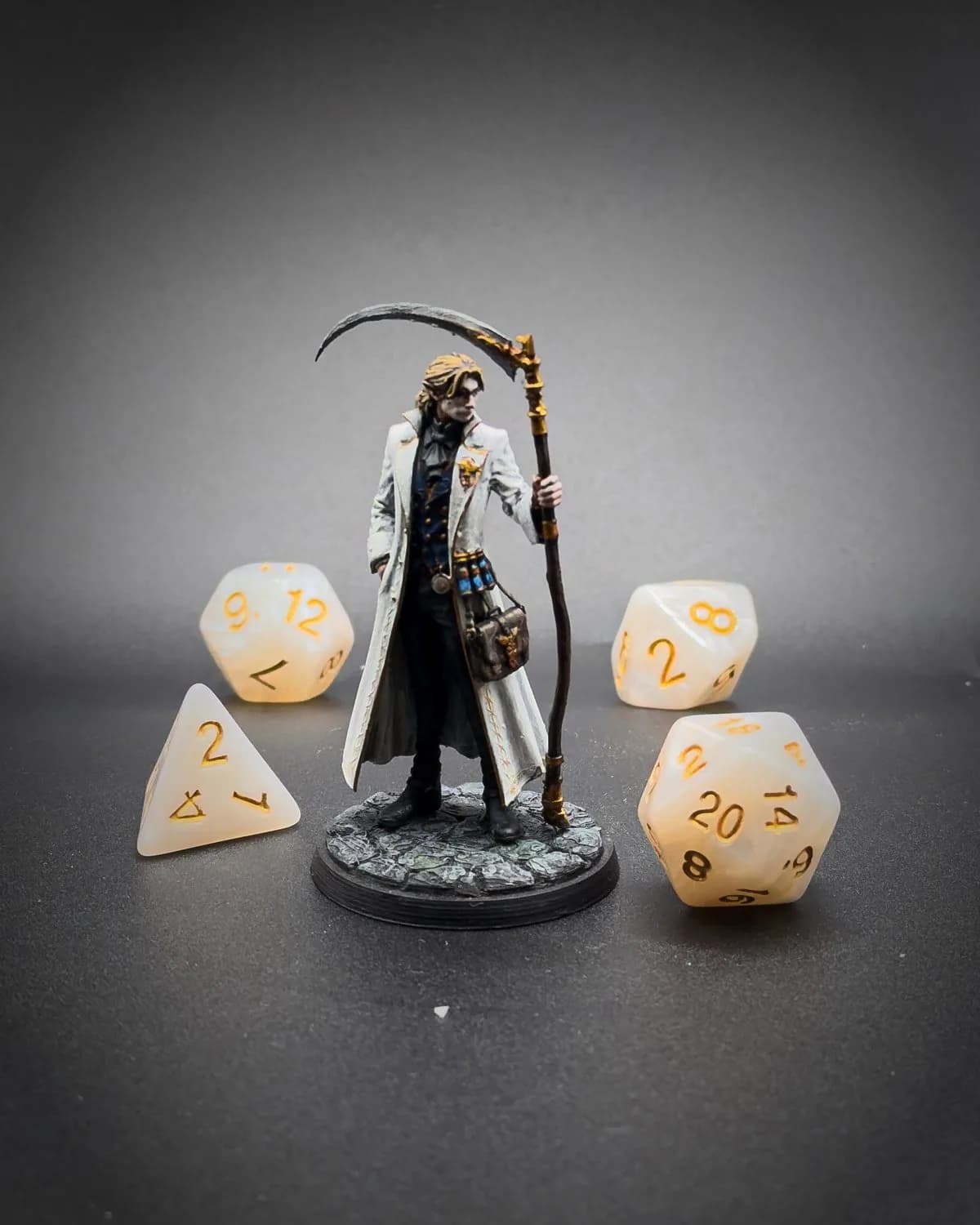 Figurine peinte d’un faucheur en long manteau blanc, faux à la main