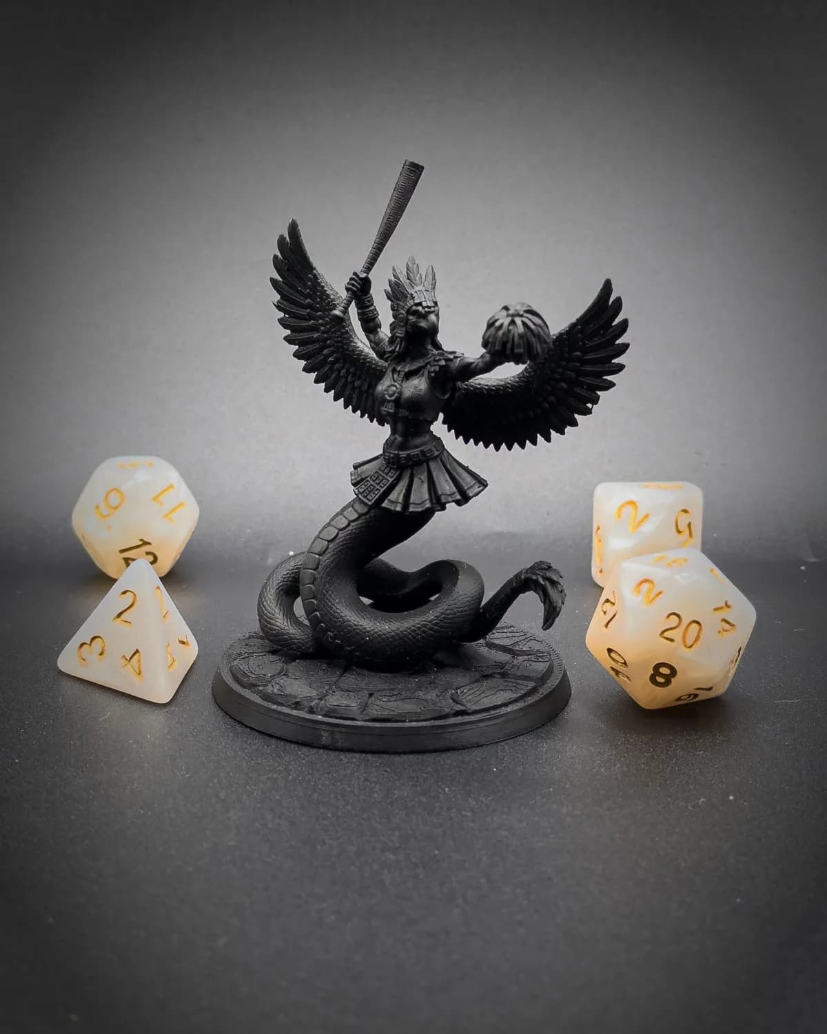Figurine sous-couchée en noir d’une naga ailée